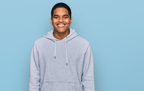Young handsome hispanic man wearing casual sweatshirt with a happy and cool smile on face. lucky person.