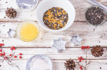 Food for birds for the winter. Seeds, millet, nuts, ghee in a bowl for making a feeder on a wooden white background.