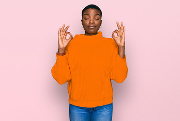 Young african american woman wearing casual clothes relax and smiling with eyes closed doing meditation gesture with fingers. yoga concept.