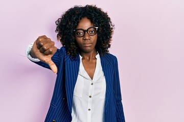 Young african american woman wearing business clothes and glasses looking unhappy and angry showing...