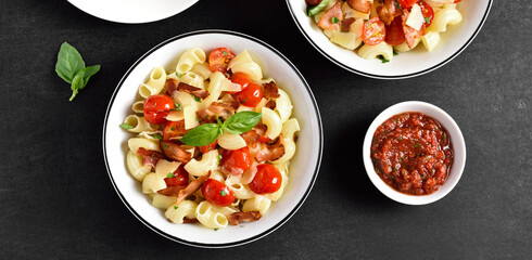Pasta with bacon, tomato, parmesan cheese and basil leaves