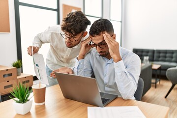 Two hispanic men business workers arguing at office