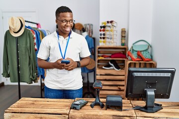 Young african man working as shop assistance using smartphone at retail shop