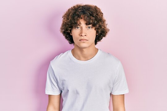 Handsome young man wearing casual white t shirt skeptic and nervous, frowning upset because of problem. negative person.