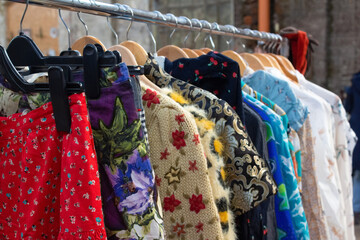 Second hand clothes on hangers for donation and reselling. Garage sale or economic shopping...