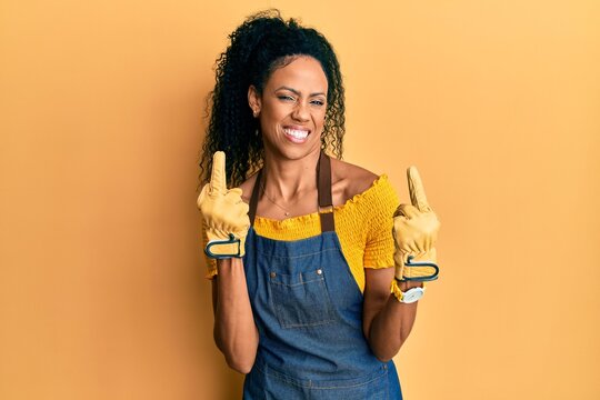 Middle age african american woman wearing professional apron showing middle finger doing fuck you bad expression, provocation and rude attitude. screaming excited
