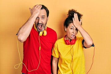 Middle age couple of hispanic woman and man wearing sportswear and arm band surprised with hand on head for mistake, remember error. forgot, bad memory concept.