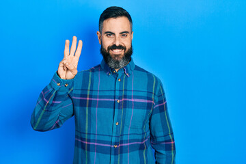 Young hispanic man wearing casual clothes showing and pointing up with fingers number three while smiling confident and happy.