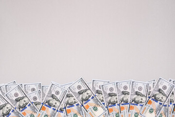 100 dollar bills wiggle on gray background. Banner about money with copy space