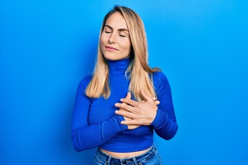 Fototapeta premium Young caucasian woman wearing casual clothes smiling with hands on chest, eyes closed with grateful gesture on face. health concept.