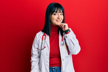 Young hispanic woman wearing doctor uniform and stethoscope looking confident at the camera smiling...