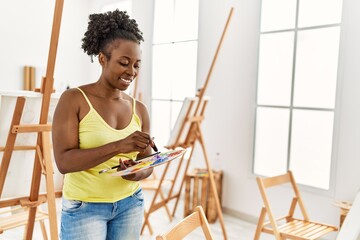 Young african american artist woman smiling happy drawing at art studio.