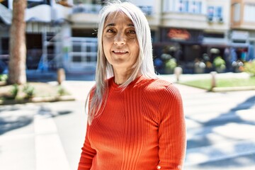 Middle age grey-haired woman smiling happy standing at the city.