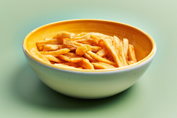  Bowl of french fried potatoes over green background