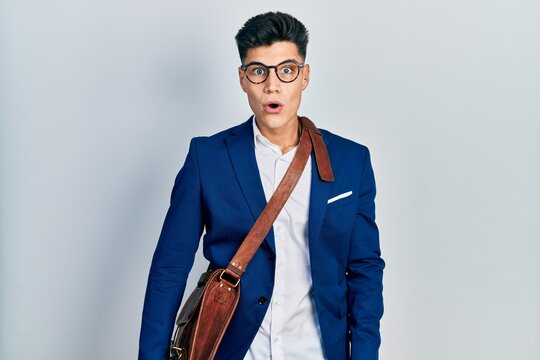 Young hispanic man wearing business clothes afraid and shocked with surprise expression, fear and excited face.