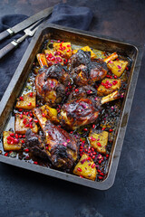 Traditional braised slow cooked Australian lamb shank with pineapple and pomegranate served as close-up in a backing form