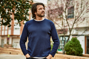 Middle age handsome man smiling outdoors at the park