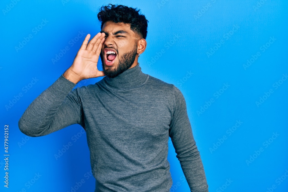 Canvas Prints arab man with beard wearing turtleneck sweater shouting and screaming loud to side with hand on mout