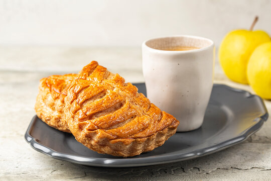 French breakfast. Apple turnovers, or chaussons aux pommes, a classic French puff pastry that is filled with apple sauce, hot coffee, fresh apples.