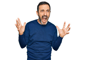 Naklejka premium Middle age hispanic man wearing casual clothes crazy and mad shouting and yelling with aggressive expression and arms raised. frustration concept.