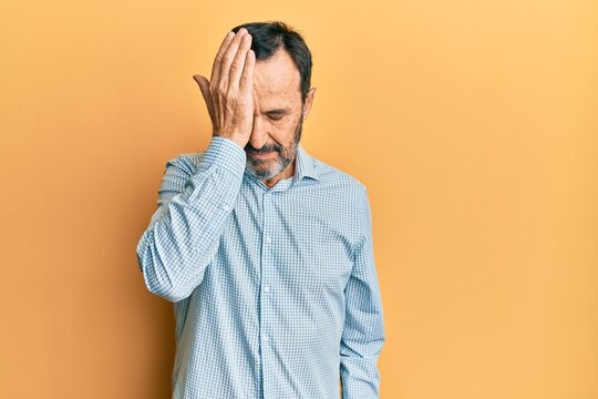 Middle age hispanic man wearing casual clothes surprised with hand on head for mistake, remember error. forgot, bad memory concept.