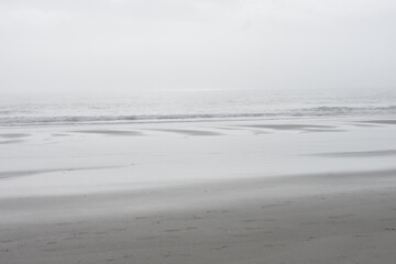 Calm serene ocean beach on a gray hazy winter afternoon