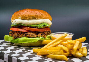 Shredded meat sandwich with avocado, tomato, lettuce and mayonnaise. served with french fries