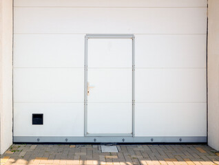 closed garage doors with automatic upward opening and built-in small door for staff