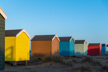 Fototapeta na wymiar FINDHORN, MORAY, SCOTLAND - 1 JANUARY 2022: This is the beach huts getting the last of the sun at Findhorn, Moray, Scotland.