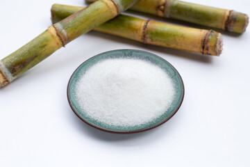 Sugar cane with sugar on white background