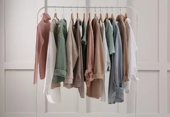 Fotobehang Rack with stylish women's clothes near light wall © New Africa