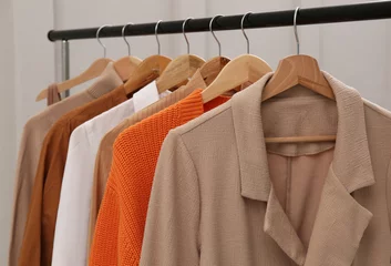 Fotobehang Rack with stylish women's clothes near light wall, closeup © New Africa