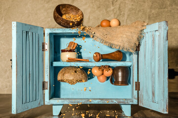 baking or breakfast ingredients in an old vintage cupboard standing on shelves and up side down, levitating food, countryside cupboard with eggs, cereals, baking ingredients inside