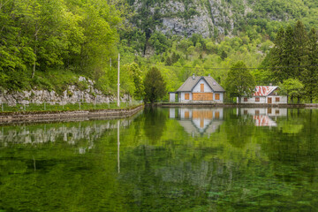 Fototapeta na wymiar Houses reflecting in Pluzensko jezero lake near Bovec village, Slovenia