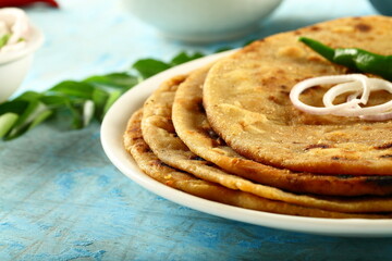 Homemade delicious Indian vegan diet meal- aloo paratha with potato curry and fresh raita.