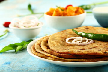 Punjabi dhaba style meal- aloo paratah with fresh raita and potato curry.