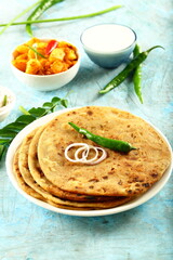 Aloo paratha - poato masala stuffed Indian flat bread served with fresh raita.