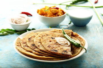 Aloo paratha - poato masala stuffed Indian flat bread served with fresh raita.