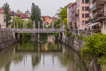 Fototapeta na wymiar LJUBLJANA, SLOVENIA - MAY 14, 2019: Riverside buildings and the Cobblers bridge in Ljubljana, Slovenia