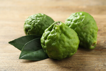 Fresh ripe bergamot fruits and leaves on wooden table