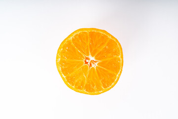 Half orange colored tangerine in the middle of a white background
