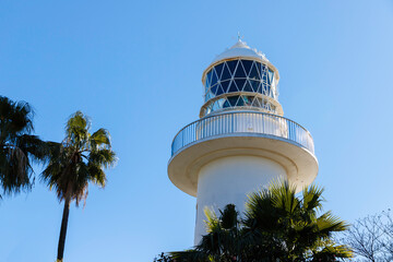 灯台、青空とパームツリーを背景に立つ白い灯台