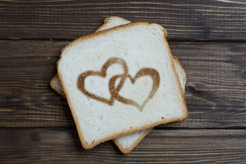 toast with the sign of love on dark wood.