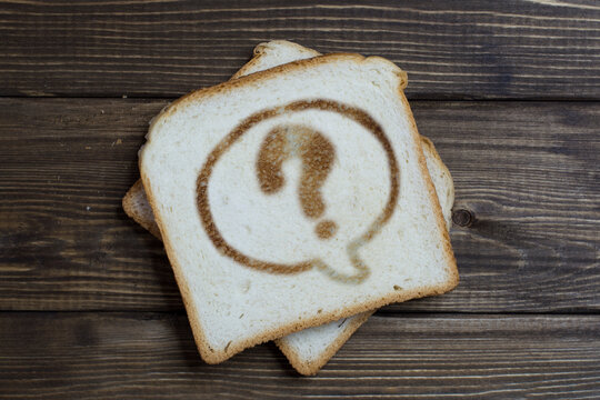 toast with question mark sign on dark wood.