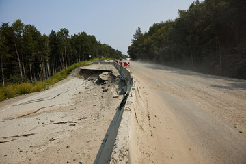 Road collapses with huge cracks. Flood damage highway. Asphalt road collapsed and fallen after heavy flood or earthquake