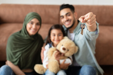 Happy arabic family showing keys of their apartment