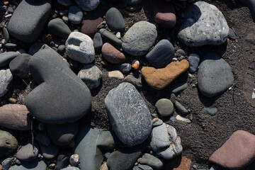 Autumn, the shallow stone-sandy bottom of a mountain river in the rays of the morning sun, close-up.