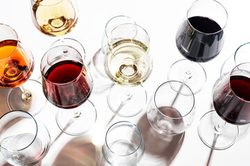 Red, white, rose wines in glasses in assortment on white background, top view. Wine bar, shop,...