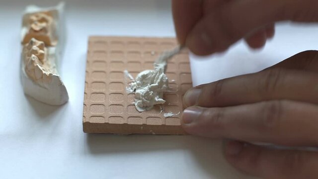 Dental technician work, denture milling, ceramic tooth crown using a plaster model, dental clinic teeth manufacturing.