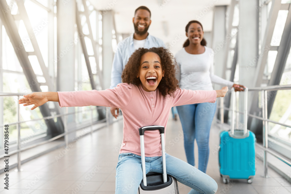 Wall mural happy black girl playing and having fun in airport